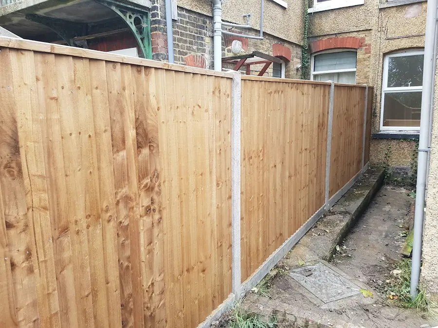 New closeboard timber fencing with concrete posts at the side of a house